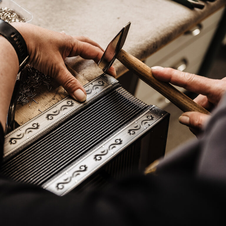 Fertigung: ein feiner Hammer und ein Teil einer Harmonika